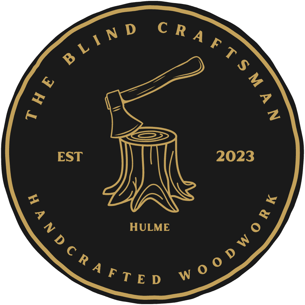 Logo of The Blind Craftsman featuring an axe and tree stump design.